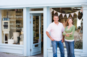 Couple standing in front of organic food store smiling