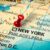 Pushpin pointing at New York City in USA, America