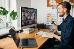 Young man having Zoom video call via a computer in the home office. Stay at home and work from home concept during Coronavirus pandemic.