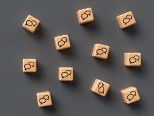 many cubes with speech bubble icons and smartphone on wooden bac